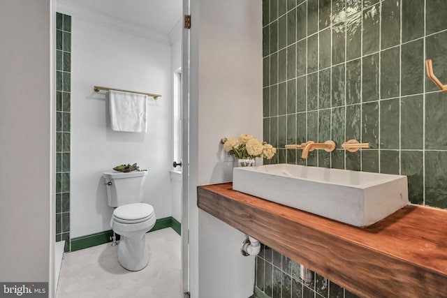 bathroom featuring crown molding, toilet, and sink