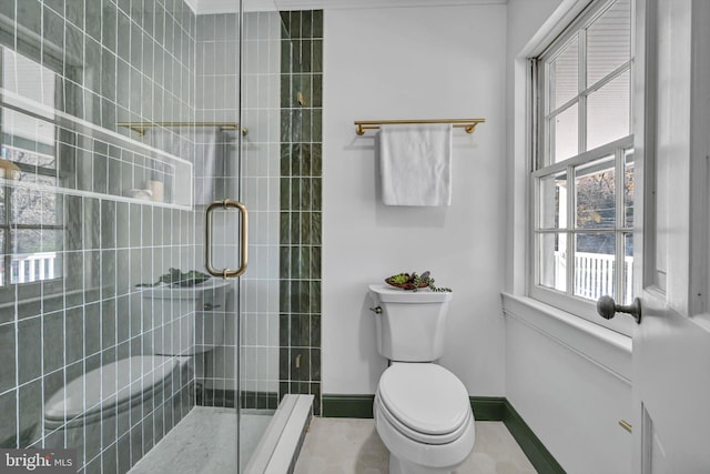 bathroom featuring tile patterned flooring, an enclosed shower, and toilet