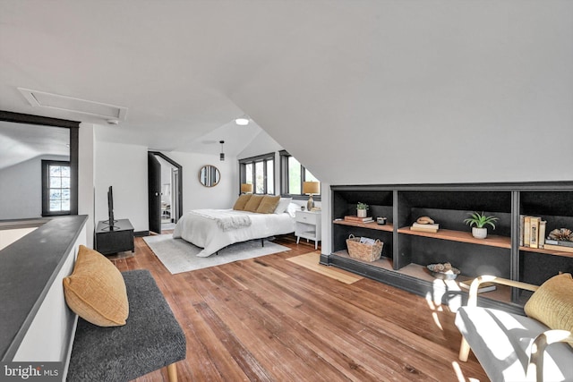 bedroom featuring hardwood / wood-style floors, multiple windows, and lofted ceiling