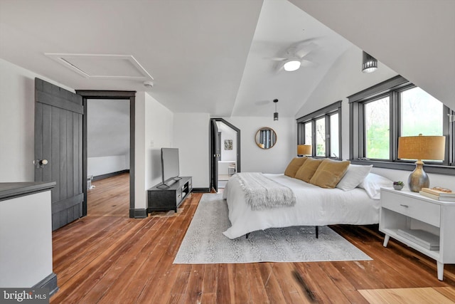 bedroom with ceiling fan, hardwood / wood-style floors, and vaulted ceiling