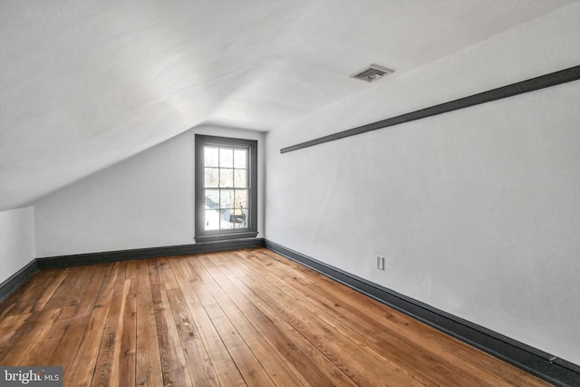 additional living space featuring hardwood / wood-style floors and lofted ceiling