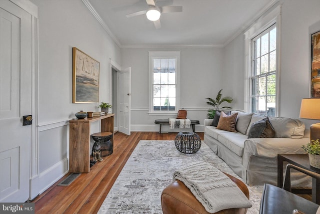 living room with hardwood / wood-style flooring, plenty of natural light, and crown molding