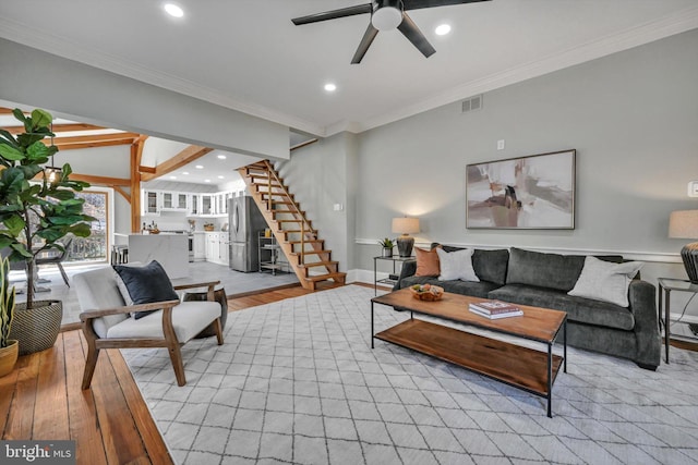 living room featuring light hardwood / wood-style flooring, ceiling fan, and ornamental molding