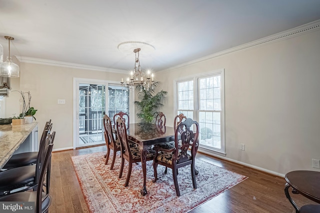 dining room with a notable chandelier, dark hardwood / wood-style flooring, and crown molding