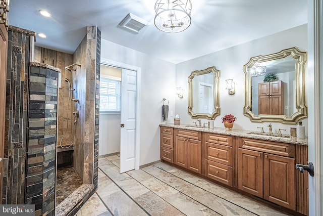 bathroom with tiled shower and vanity