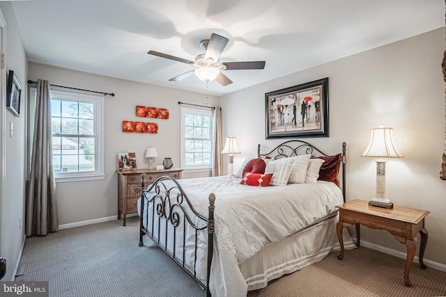 carpeted bedroom featuring ceiling fan and multiple windows