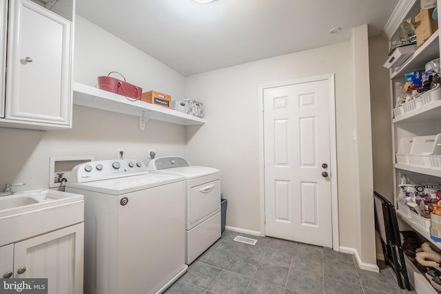 laundry room featuring washer and clothes dryer and cabinets