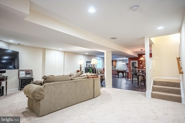 carpeted living room featuring an inviting chandelier