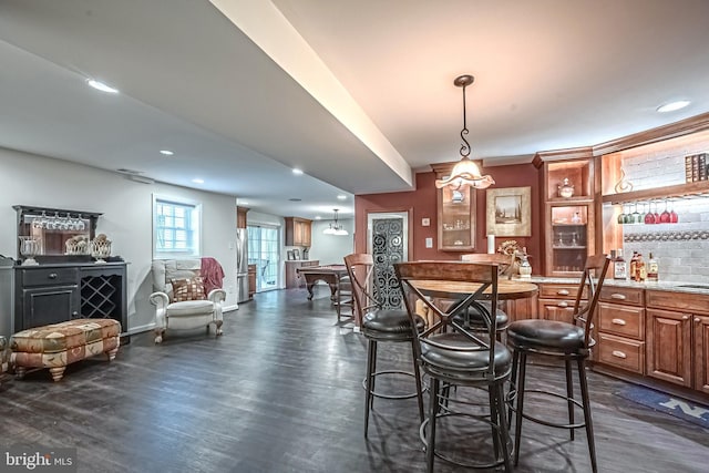 dining space featuring dark wood-type flooring and bar area