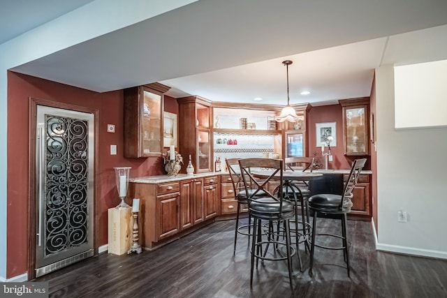 interior space with a breakfast bar area, a center island, pendant lighting, and dark hardwood / wood-style floors