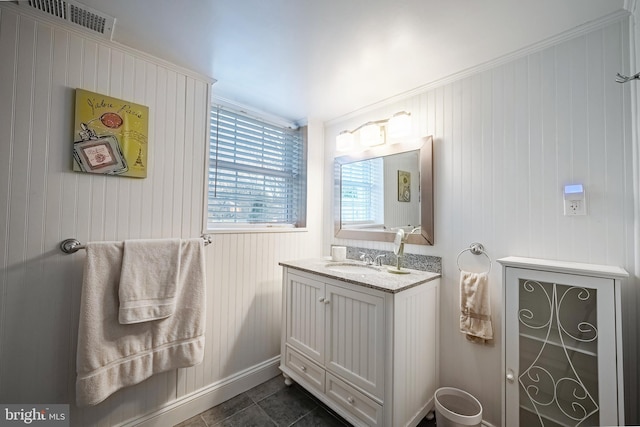 bathroom featuring tile patterned floors, vanity, crown molding, and wooden walls