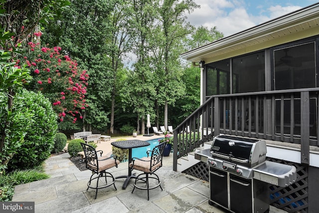 view of patio / terrace featuring a fire pit, grilling area, and a sunroom