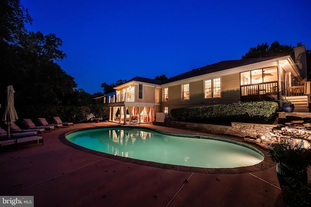 pool at night with a patio area