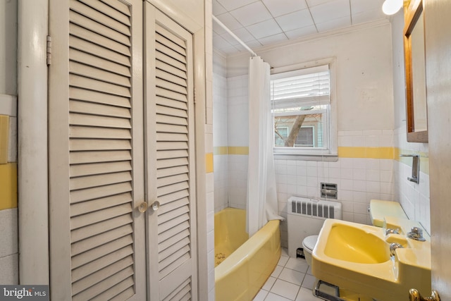 bathroom featuring radiator, sink, tile walls, shower / tub combo, and tile patterned floors