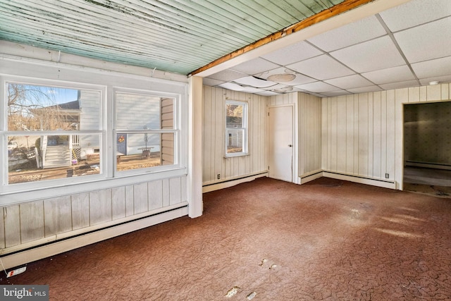 unfurnished room featuring a baseboard radiator, carpet flooring, and a paneled ceiling