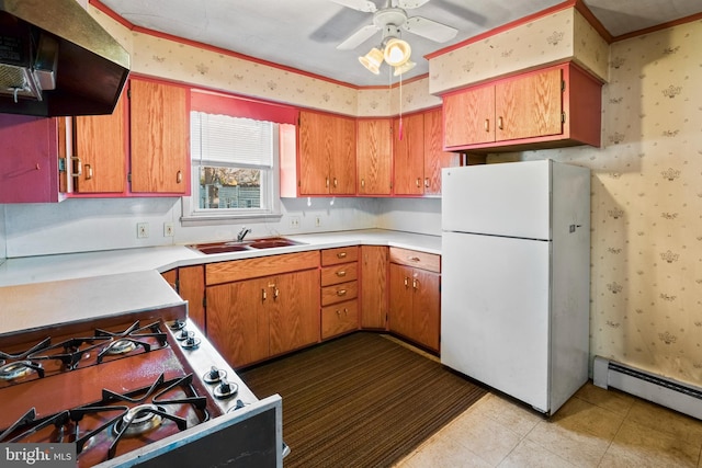 kitchen featuring sink, white refrigerator, a baseboard heating unit, exhaust hood, and gas stove