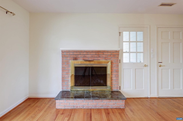 details with hardwood / wood-style flooring and a brick fireplace