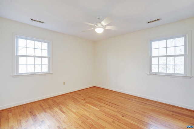 spare room with plenty of natural light, light hardwood / wood-style floors, and ceiling fan