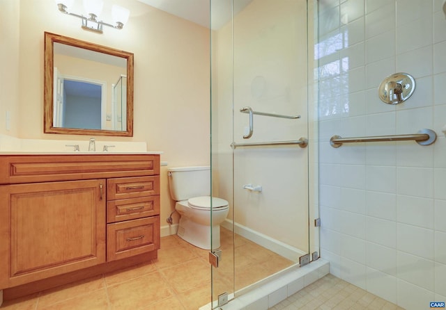 bathroom featuring a tile shower, tile patterned flooring, vanity, and toilet