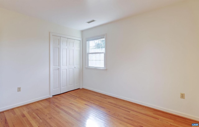 unfurnished bedroom with a closet and light hardwood / wood-style floors