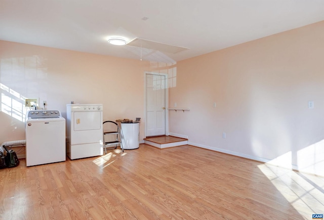 clothes washing area featuring washer and dryer and light hardwood / wood-style flooring