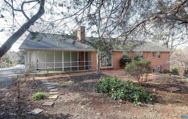 rear view of house featuring a sunroom