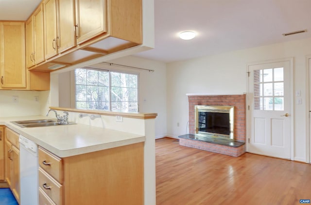 kitchen featuring sink, dishwasher, light wood-type flooring, and light brown cabinets