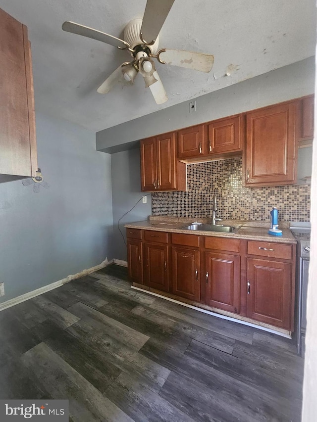 kitchen featuring dark wood-type flooring, tasteful backsplash, a ceiling fan, and a sink