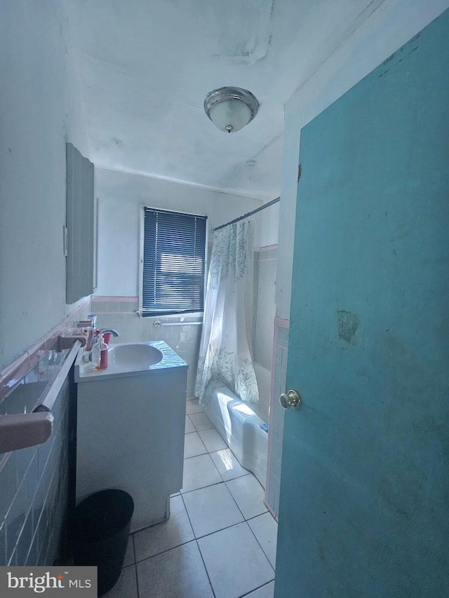 full bath with tile walls, vanity, shower / bath combination with curtain, tile patterned flooring, and wainscoting