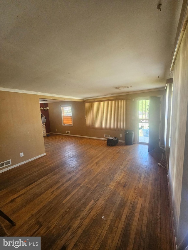 unfurnished living room featuring visible vents, a wealth of natural light, wood finished floors, and baseboards