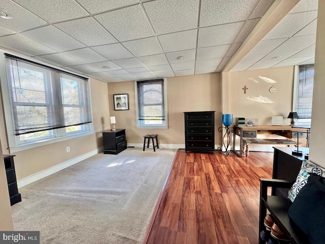 sitting room with a paneled ceiling and hardwood / wood-style flooring