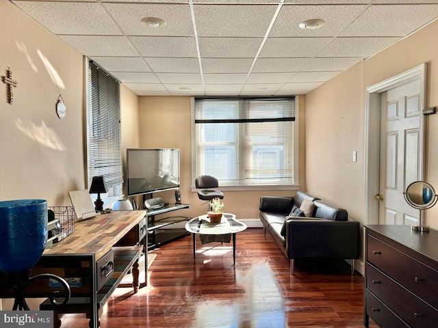 interior space with a drop ceiling and dark wood-type flooring