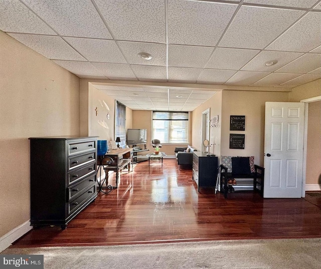 carpeted living room with a drop ceiling