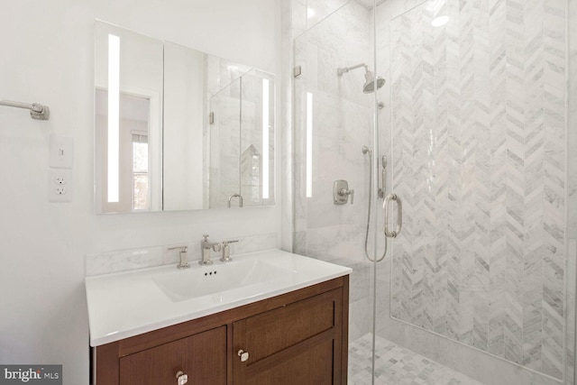 bathroom featuring vanity and a shower with door