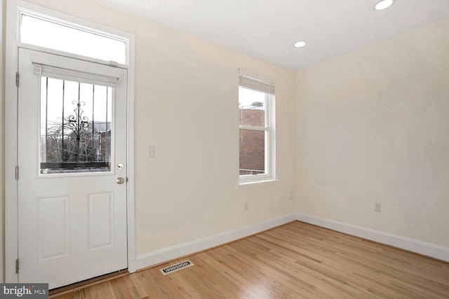 foyer entrance with light wood-type flooring and a wealth of natural light