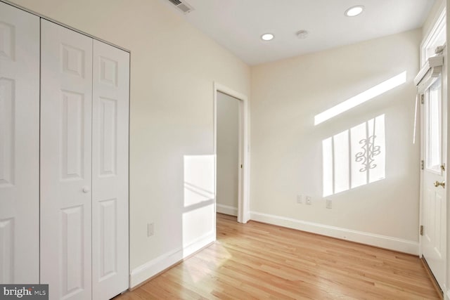 unfurnished bedroom featuring a closet and light hardwood / wood-style flooring