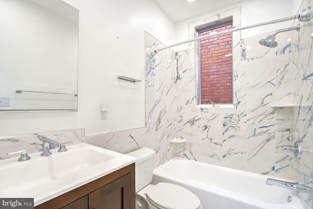 full bathroom with vanity, toilet, tiled shower / bath, and tile walls