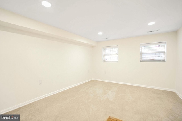 spare room featuring carpet flooring and a wealth of natural light