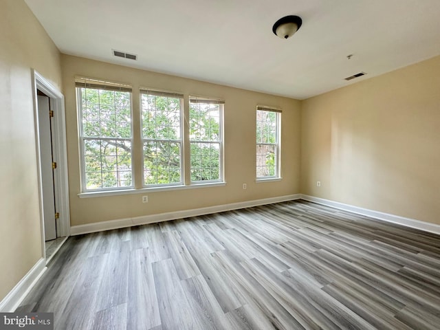 unfurnished room with light hardwood / wood-style floors and a healthy amount of sunlight