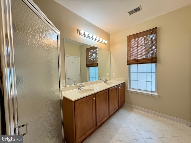 bathroom with tile patterned flooring, vanity, and an enclosed shower