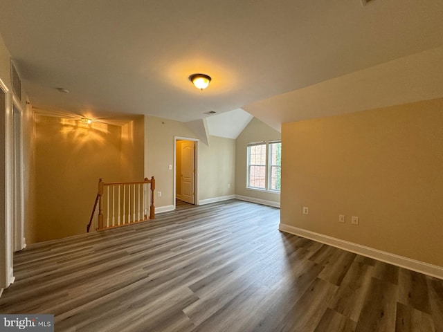 additional living space with vaulted ceiling and hardwood / wood-style flooring