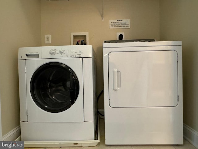 clothes washing area featuring washing machine and dryer and light tile patterned flooring