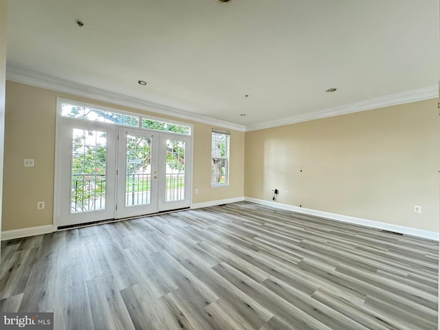 unfurnished room featuring french doors, light hardwood / wood-style floors, and ornamental molding