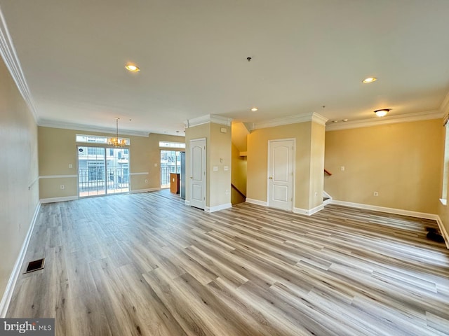 unfurnished living room with crown molding, light hardwood / wood-style flooring, and a chandelier