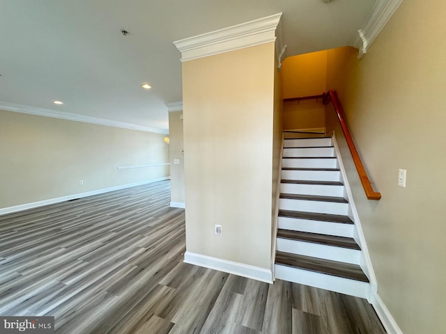 staircase with wood-type flooring and crown molding