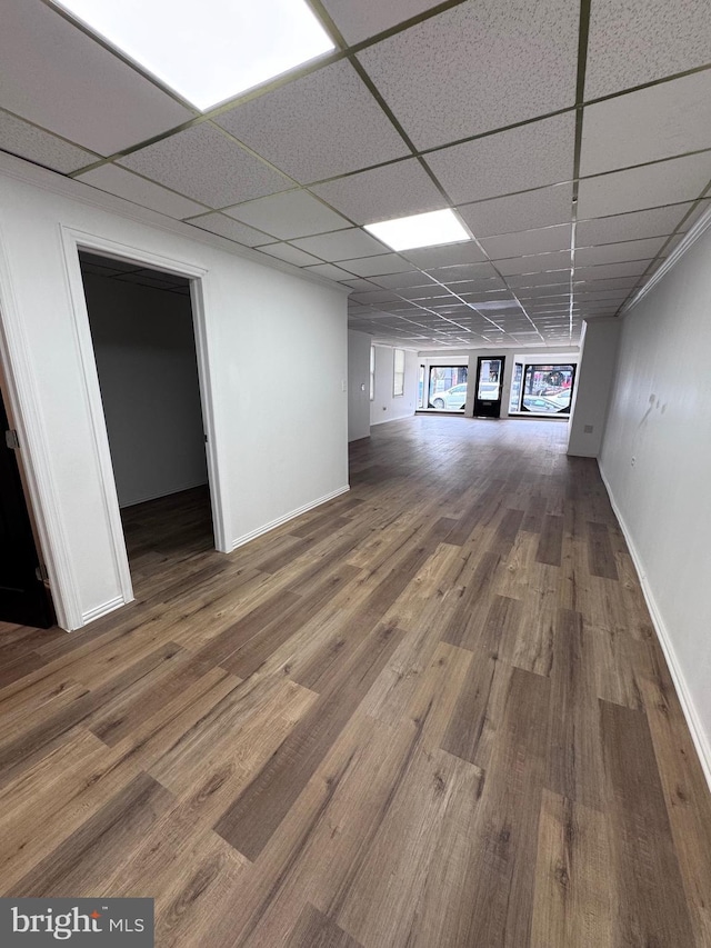 basement featuring a paneled ceiling and hardwood / wood-style flooring