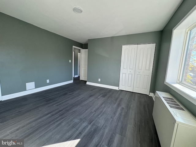 unfurnished bedroom with a closet and dark hardwood / wood-style floors