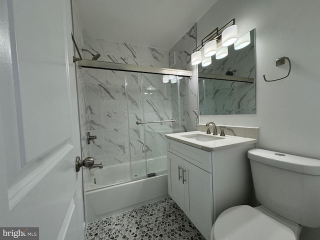 full bathroom featuring vanity, toilet, and shower / bath combination with glass door