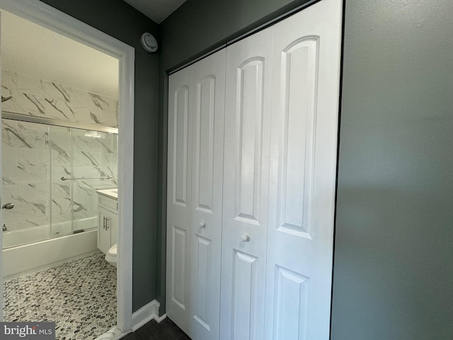 full bathroom with vanity, bath / shower combo with glass door, and toilet