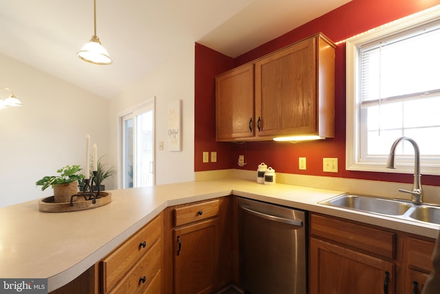 kitchen featuring kitchen peninsula, stainless steel dishwasher, vaulted ceiling, sink, and hanging light fixtures